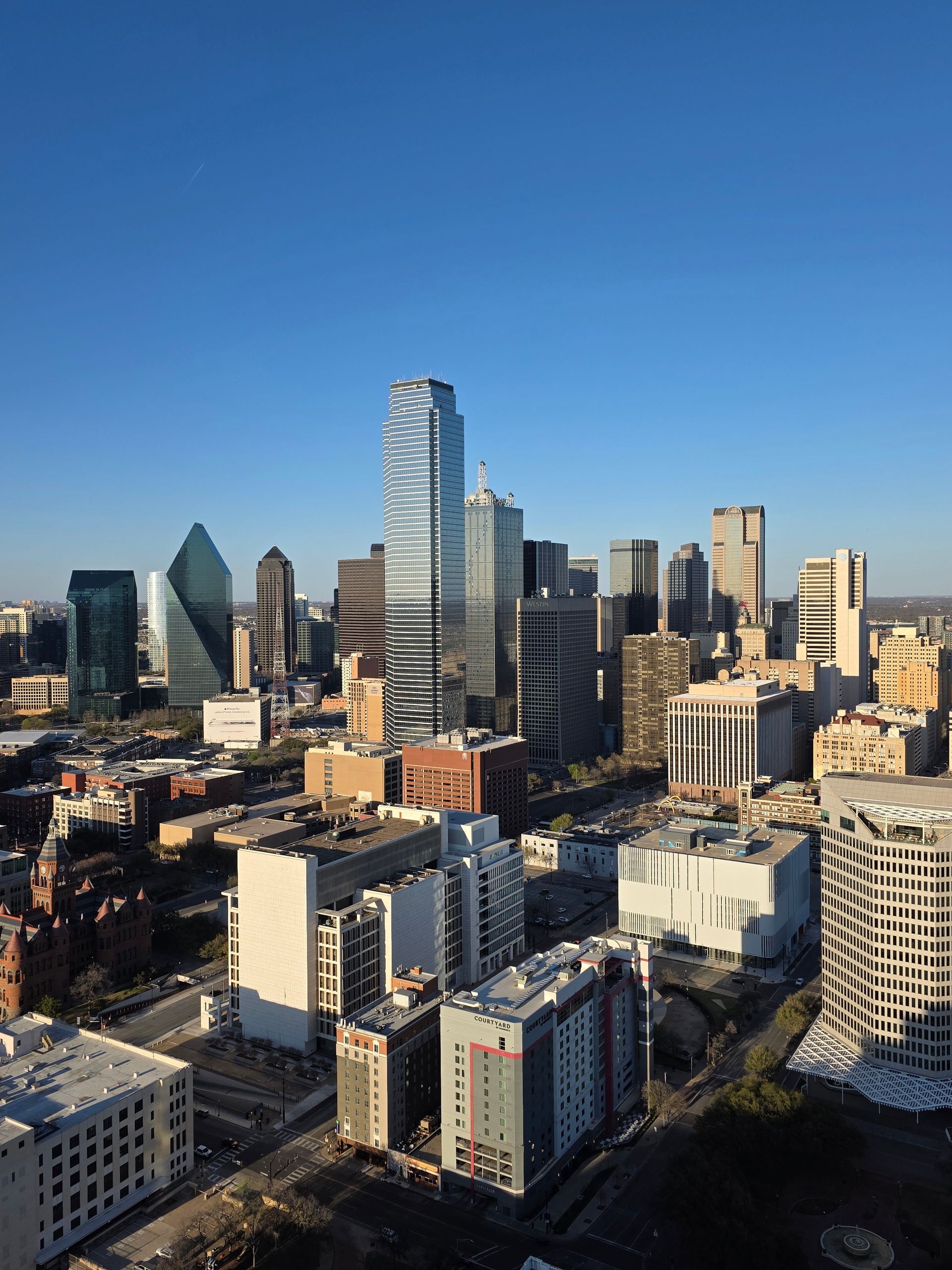 The downtown Dallas skyline under a clear blue sky.